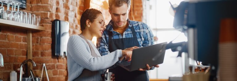 Deux personnes en train d'échanger devant l'écran de l'ordinateur portable.